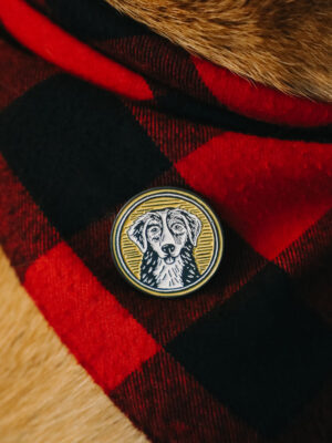 Yellow Yonder dog pin on a red buffalo plaid bandana